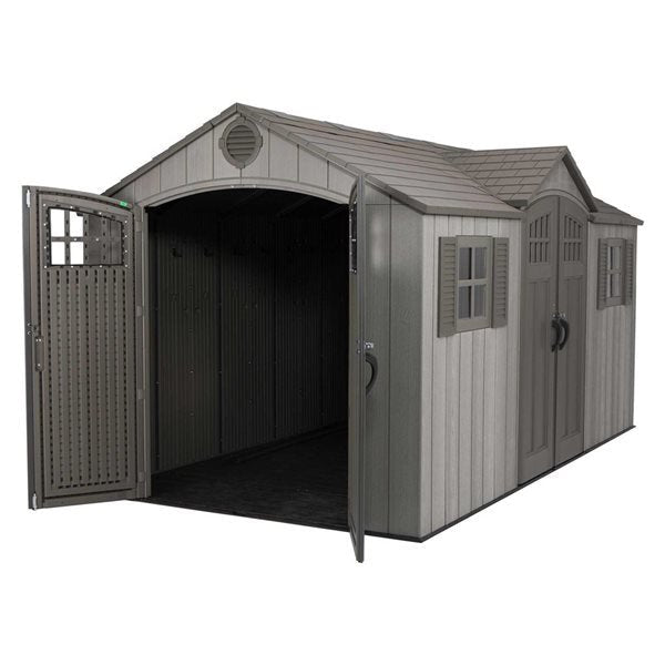 Gray shed with double doors, one open, showing the interior, and windows with shutters.