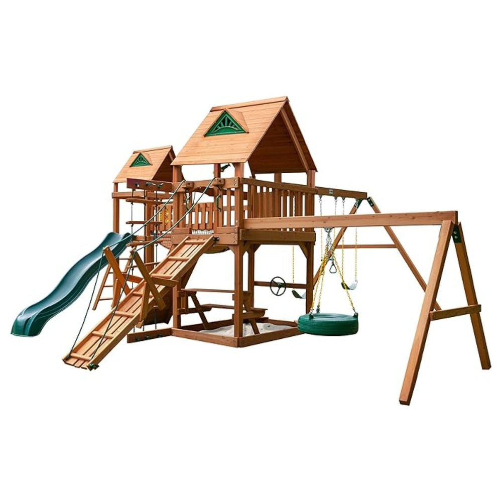 The Gorilla Playsets Pioneer Peak Treehouse Wooden Swing Set features two roofed platforms, a green slide, climbing wall, ladder, rope, tire swing, clatter bridge and tower, plus two yellow swings—all on a sturdy wooden frame.
